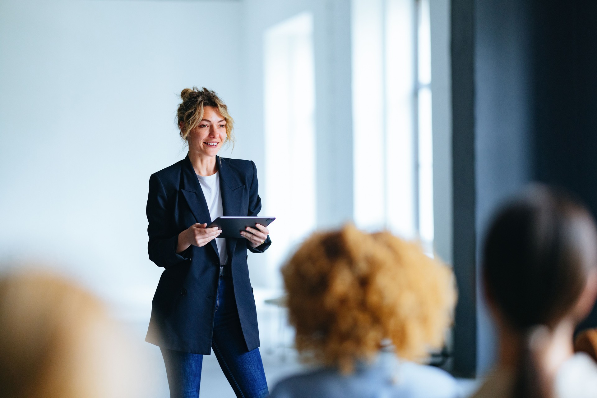 Happy Business Woman Holding A Digital Tablet And Talking To Audience During A Presentation